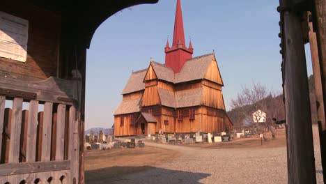 Tilt-up-through-a-gate-in-front-of-an-old-wooden-stave-church-in-Norway