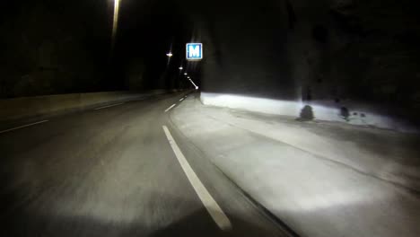 POV-shot-of-a-car-traveling-through-a-single-lane-tunnel-through-a-montaña