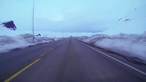 Pov-Aufnahme-Eines-Autos,-Das-Mit-Hoher-Geschwindigkeit-Auf-Einer-Bergstraße-Mit-Eis-Und-Schnee-Fährt