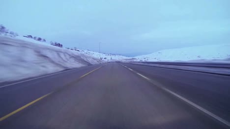 POV-shot-of-a-car-traveling-at-high-speed-along-a-mountain-road-with-ice-and-snow-4