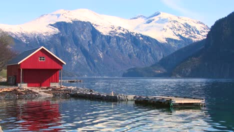 Beautiful-wide-shot-of-the-fjords-of-Norway-with-red-boathouse