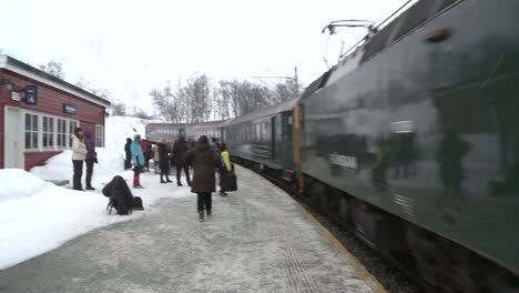 A-train-arrives-at-a-snowy-montaña-station-in-Norway