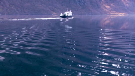 A-ferry-boat-sails-across-a-Norway-fjord-leaving-patterns-in-its-wake