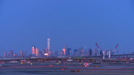 Flugzeuge-Taxi-Am-Newark-Airport-In-Der-Abenddämmerung-Mit-Manhattan-Skyline-Hintergrund