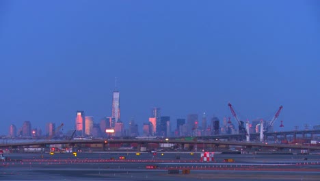 Aviones-Taxi-En-El-Aeropuerto-De-Newark-Al-Anochecer-Con-El-Fondo-Del-Horizonte-De-Manhattan