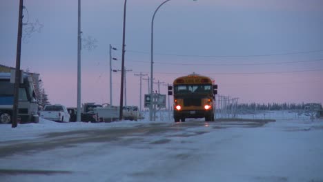 Un-Autobús-Escolar-Viaja-A-Lo-Largo-De-Una-Carretera-Helada-Y-Nevada-En-Churchill,-Manitoba,-Canadá,-La-Bahía-De-Hudson