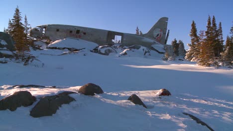 Pan-across-a-crashed-plane-sits-on-a-frozen-snowy-mountainside-in-the-Arctic