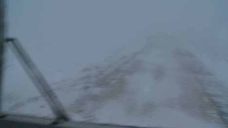 Point-of-view-shot-from-a-tundra-vehicle-of-frozen-tundra-and-barely-visible-road-in-the-Arctic-during-an-intense-blizzard