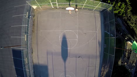 A-birds-eye-vista-aérea-over-a-basketball-player-conduciendo-to-the-basket-on-an-outdoor-court