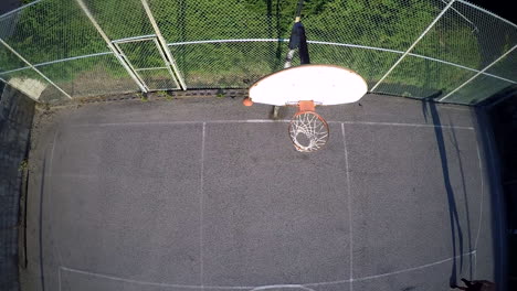 A-birds-eye-vista-aérea-over-a-basketball-player-taking-a-jump-shot-on-an-outdoor-court