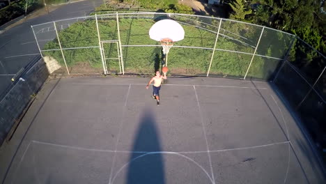 Eine-Vogelperspektive-über-Einem-Basketballspieler,-Der-Auf-Einem-Außenplatz-Einen-Layup-Schießt