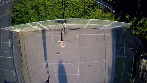 Eine-Vogelperspektive-über-Einem-Basketballspieler,-Der-Auf-Einem-Außenplatz-Einen-Sprungschuss-Schießt