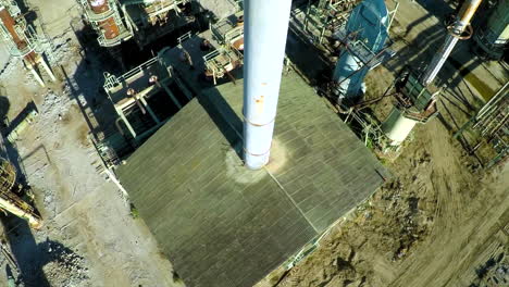 Aerial-looking-down-a-smokestack-over-an-abandoned-oil-refinery-1