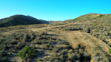 Hermosa-Toma-Aérea-Sobre-Las-Colinas-Del-Sur-De-California-Con-Un-Excursionista-Caminando-Por-Un-Sendero