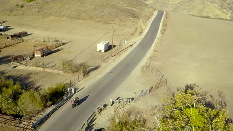 A-beautiful-vista-aérea-shot-over-a-man-riding-his-Harley-motorcycle-on-the-open-road-1