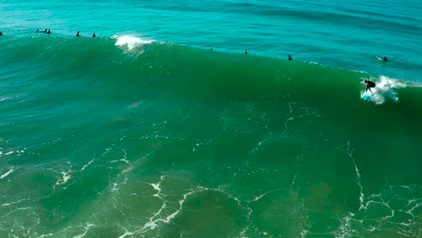 Antena-Sobre-Surfistas-Montando-Olas-En-Una-Playa-Del-Sur-De-California