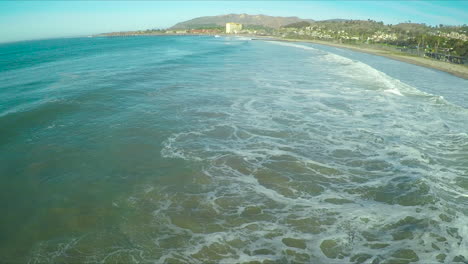 Pan-across-large-waves-breaking-onto-the-shore-in-Ventura-California
