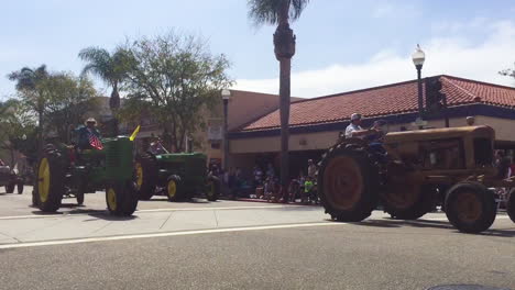 Farmers-drive-their-tractors-down-a-city-street-during-a-4th-of-July-parade-in-a-small-town-1