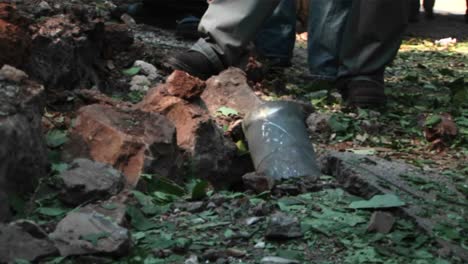 Israeli-civilians-look-at-the-remains-of-a-mortar-shell-in-a-forest