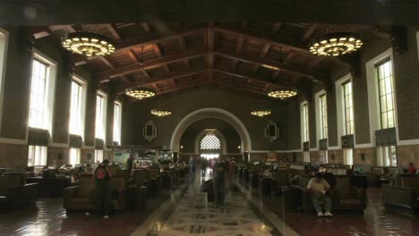 A-time-lapse-of-people-sitting-and-walking-though-a-building-with-rows-of-chairs-1