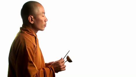 Ein-Buddhistischer-Mönch-In-Einem-Orangefarbenen-Gewand-Klopft-Mit-Einem-Kleinen-Stock-Auf-Eine-Glocke-2