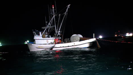 A-fishing-boat-equipped-with-a-net-and-a-winch-is-working-at-night
