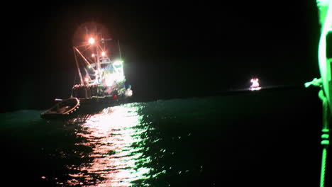 Ein-Fischkutter-Arbeitet-Nachts-Bei-Eingeschaltetem-Licht