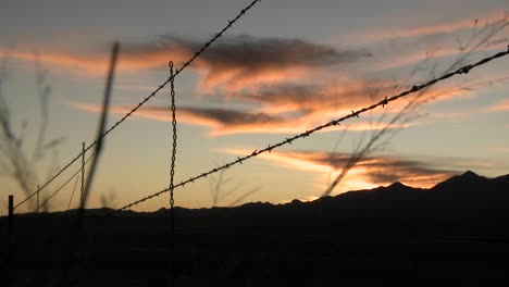 The-sun-sets-over-an-area-protected-by-barbed-wire