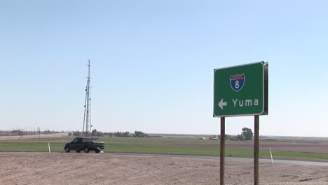 A-truck-drives-by-a-road-sign-pointing-to-Yuma