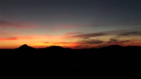 Bewölkter-Orange-Sonnenuntergang-Blauer-Himmel-Und-Dunkle-Landschaft