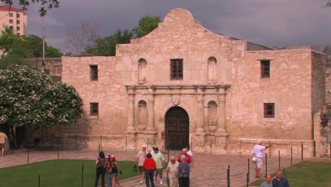 People-walk-around-a-stone-courtyard-and-building-in-San-Antonio-Texas-1