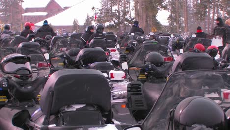 Many-snowmobiles-are-lined-up-in-a-snowmobile-parking-lot-1
