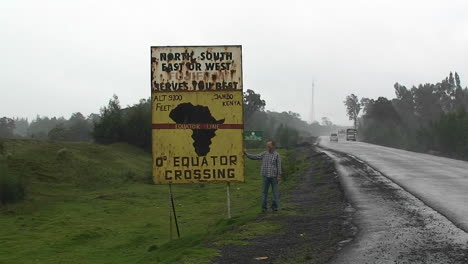 Ein-Mann-Steht-Neben-Einem-Schild,-Das-Die-Äquatorüberquerung-Ankündigt