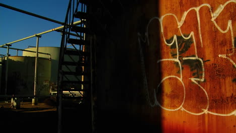 Zeitraffer-Einer-Mit-Graffiti-Bedeckten-Wand,-Die-In-Einem-Industriegebiet-In-Den-Schatten-Geht