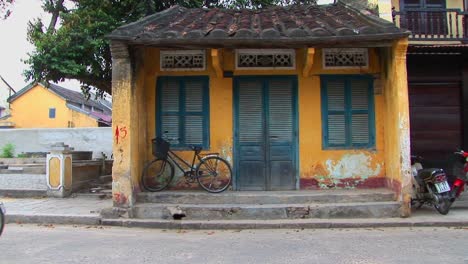 Personas-Y-Vehículos-Se-Mueven-Por-Un-Pequeño-Edificio-En-La-Zona-Rural-De-Vietnam