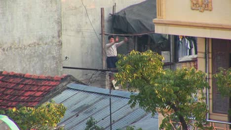A-man-exercises-on-his-rooftop-in-the-early-morning-in-Vietnam