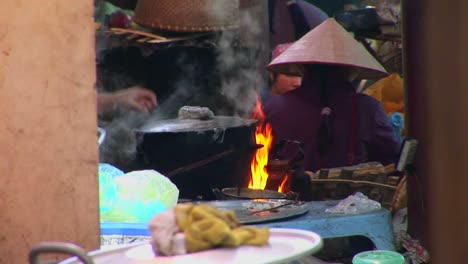 Feuer-Brennen-Und-Ein-Topf-Kocht,-Während-Vietnamesische-Dorfbewohner-Eine-Mahlzeit-Zubereiten