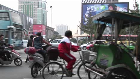 Auf-Einer-Pekinger-China-Straße-Mit-Modernen-Werbetafeln-Im-Hintergrund-Ziehen-Große-Mengen-An-Verkehr-Vorbei
