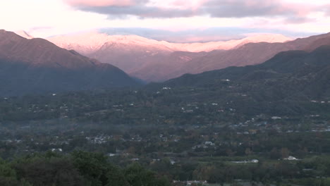 Wide-zoom-out-of-sunrise-on-the-snowcovered-Santa-Ynez-Mountains-above-Ojai-California