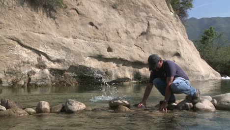 Man-removing-rocks-from-a-fish-barrier-on-the-Ventura-Río-Preserve-in-Ojai-California