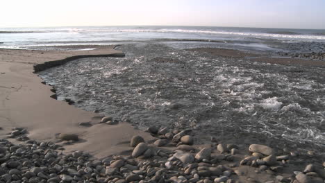 Water-flowing-out-of-the-Ventura-Río-estuary-at-Surfers-Point-in-Ventura-California
