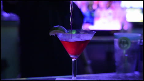 Barkeeper,-Der-In-Einem-Nachtclub-In-San-Diego,-Kalifornien,-Einen-Geschüttelten-Cocktail-In-Ein-Gekühltes-Glas-Gießt