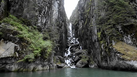 POV-boat-ride-entering-a-very-steep-chasm-with-waterfall-in-the-fjords-in-Fords-Terror-in-Tracy-ArmFords-Terror-Wilderness-Area-Southeast-Alaska