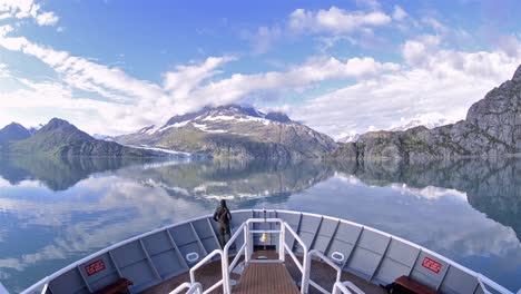 A-person-on-the-bow-of-a-ship-entering-Johns-Hopkins-Inlet-in-Glacier-Bay-National-Park-Alaska