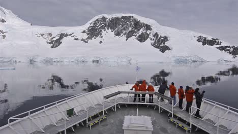 Panning-across-a-ship\'s-bow-with-tourists-in-the-Lemaire-Channel-in-Antarctica