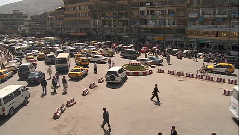 A-wide-establishing-shot-of-downtown-Kabul-Afghanistan-with-bus-taxi-and-vehicle-traffic
