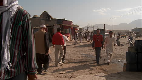 Slow-mo-shot-of-people-walking-on-dirt-streets-of-Kabul-Afghanistan