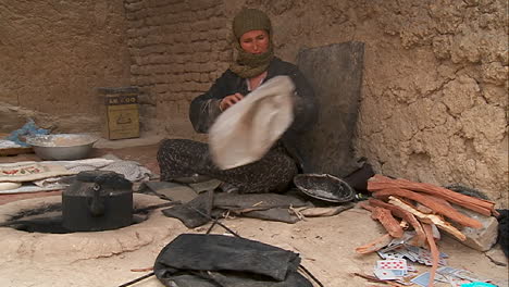 A-woman-puts-wood-into-a-tandor-oven-in-Kabul-Afghanistan