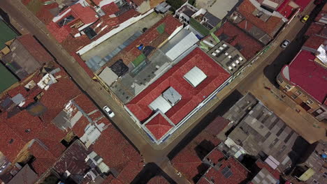 Aerial-establishing-shot-looking-down-of-a-red-tile-roofed-neighborhood-and-streets-in-Bogota-Colombia