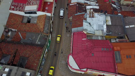 Aerial-establishing-shot-looking-down-on-a-taxi-motorcycle-and-car-driving-on-streets-in-Bogota-Colombia